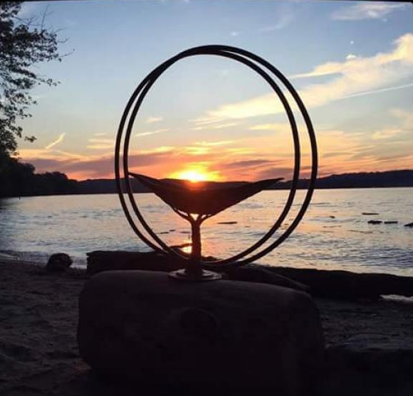 UU Chalice on a beach, lit by the sunset.